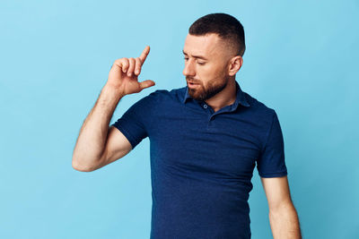 Young man standing against blue background