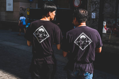 Rear view of people walking on street in city