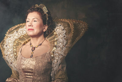 Woman standing against black background