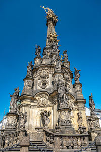Low angle view of statue against blue sky olomouc czech republic 