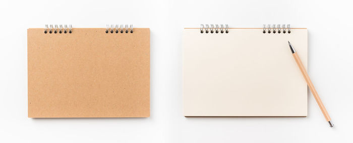 Directly above shot of spiral notebooks against white background