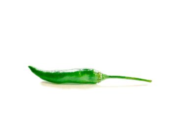 Close-up of green chili pepper against white background