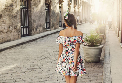 Rear view of woman standing on footpath