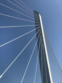 Low angle view of suspension bridge against clear blue sky