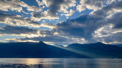 Scenic view of lake by mountains against sky