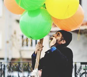 Rear view of woman holding balloons