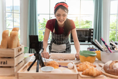 Portrait of young woman preparing food at home