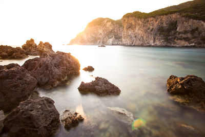 Rocks on sea shore against sky