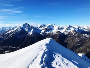 Scenic view of snowcapped mountains against blue sky