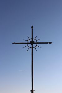 Low angle view of wind turbine against clear blue sky