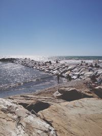 Scenic view of groyne amidst sea against clear sky