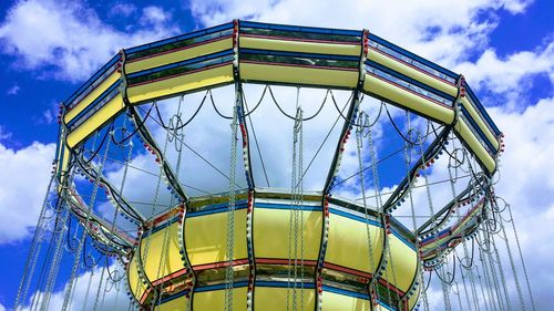 Low angle view of ferris wheel against blue sky