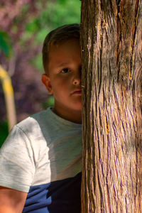 Portrait of boy in tree trunk