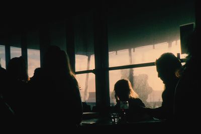 Silhouette people sitting in dark