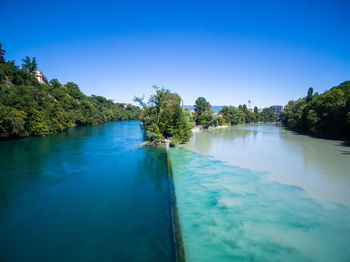 Scenic view of river against clear blue sky