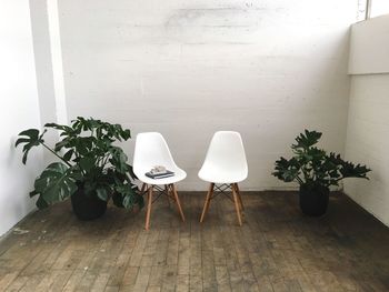 Books on chair against white wall