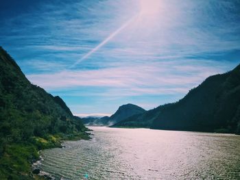 Scenic view of river and mountains against sky