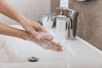 Washing hands under the flowing water tap. hygiene concept hand detail. washing hands rubbing