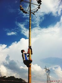 Low angle view of lamp post against cloudy sky