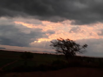 Low angle view of storm clouds over silhouette landscape