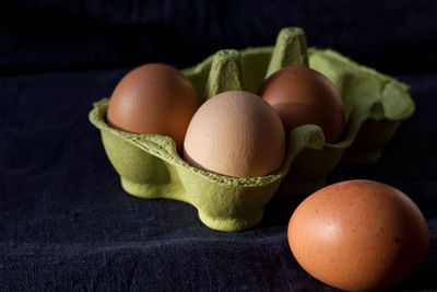 Eggs in carton agains dark background