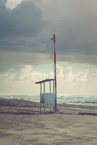 Lifeguard hut on beach against sky