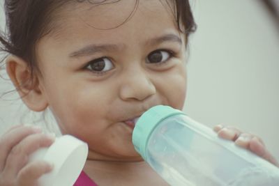 Close-up portrait of cute boy drinking glass