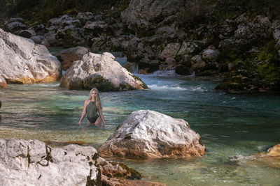 Man standing on rock by river