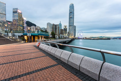 Empty footpath by lake in city