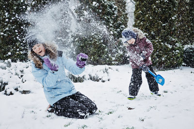 Happy family, mother and son having fun outdoors in winter snowy nature background. mom and kid