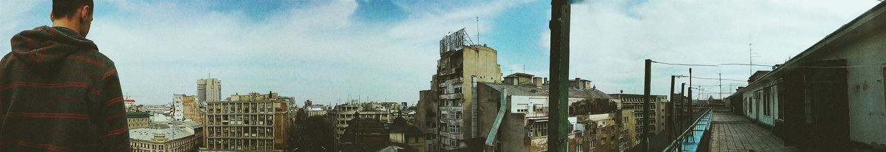 Buildings in city against cloudy sky