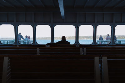 People sitting by window in sea