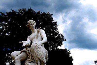 Low angle view of statue against trees against sky