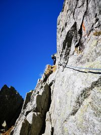 Low angle view of rock formation against clear blue sky