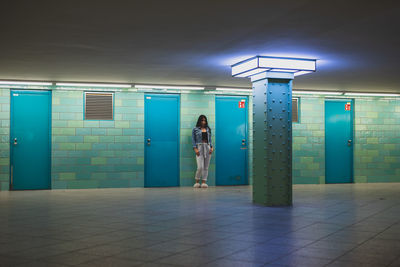 Full length of young woman standing against wall