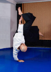 Full length of man sitting on wall