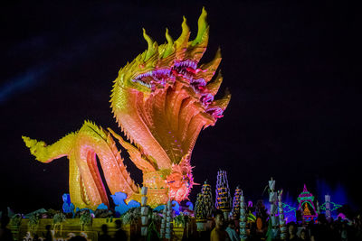 Low angle view of illuminated statue against sky at night