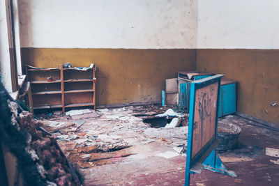 Abandoned chair against wall in building