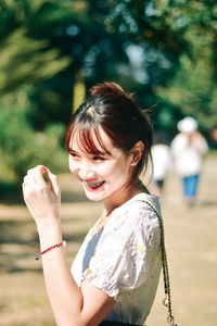 Side view of young woman sitting on field