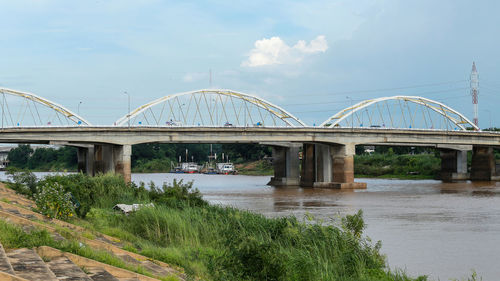 Arch bridge over river against sky