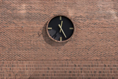 Low angle view of clock on brick wall