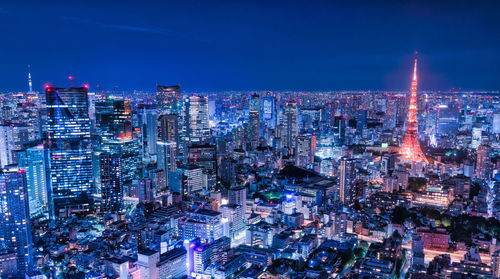 Illuminated cityscape against sky at night