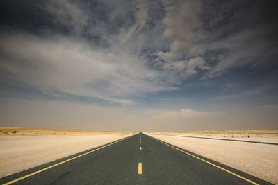 Empty road against cloudy sky