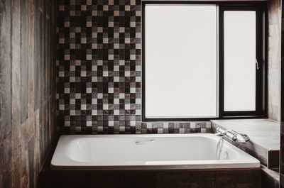 White bathtub in rustic loft bathroom. dark tone