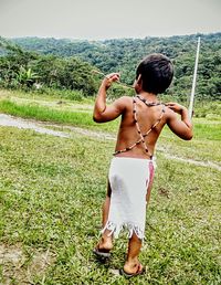 Full length of boy standing in grass