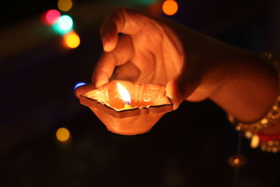 Close-up of hand holding lit diya