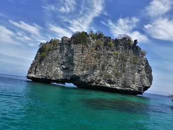 Rock formation in sea against sky