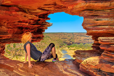 Woman sitting on rock formation at kalbarri national park 