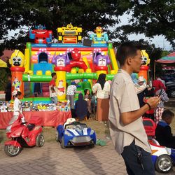 People standing by toy car at market