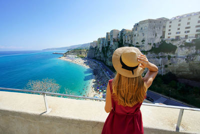 Vacation in tropea, italy. rear view of beautiful girl enjoying landscape of tropea, calabria